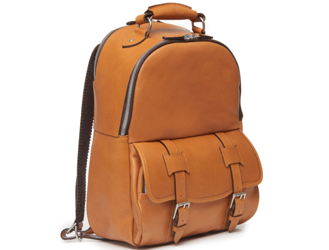 Tan Handcrafted with full grain American leather Padded backpack shoulder straps Roomy interior and front pocket Keychain attachment Interior organizer panel Fits up to a 15" laptop  Strap designed for easy carry on telescoping luggage handles Handcrafted with care in our own factory Natural leather lining Dimensions: 17" x 7" x 12" #color_tan