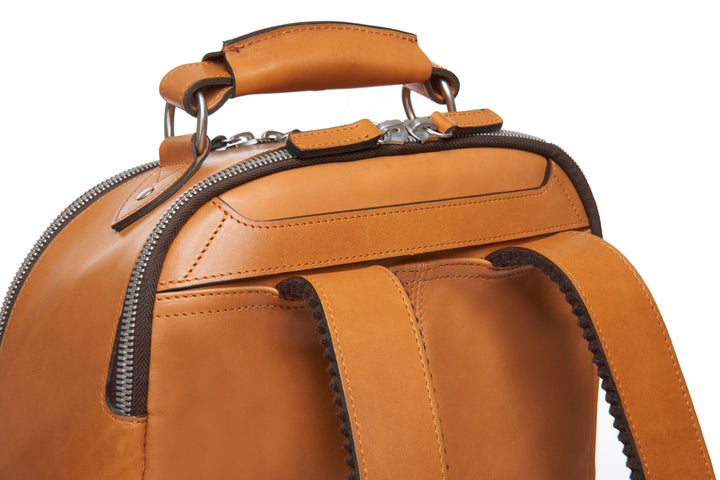 Tan Handcrafted with full grain American leather Padded backpack shoulder straps Roomy interior and front pocket Keychain attachment Interior organizer panel Fits up to a 15" laptop  Strap designed for easy carry on telescoping luggage handles Handcrafted with care in our own factory Natural leather lining Dimensions: 17" x 7" x 12" #color_tan