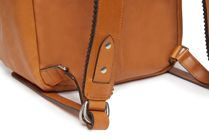 Tan Handcrafted with full grain American leather Padded backpack shoulder straps Roomy interior and front pocket Keychain attachment Interior organizer panel Fits up to a 15" laptop  Strap designed for easy carry on telescoping luggage handles Handcrafted with care in our own factory Natural leather lining Dimensions: 17" x 7" x 12" #color_tan