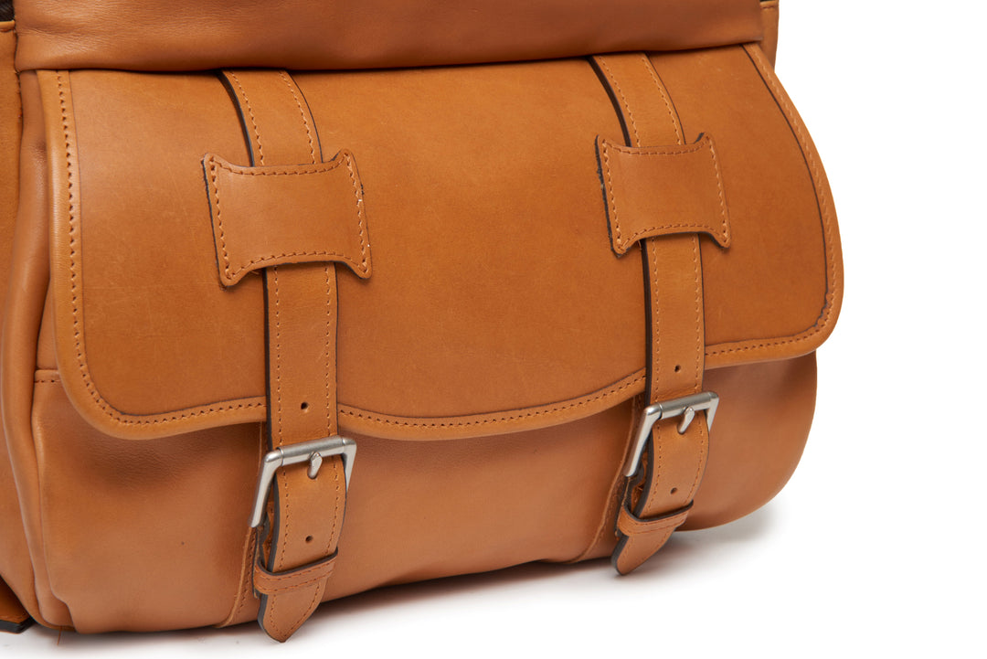 Tan Handcrafted with full grain American leather Padded backpack shoulder straps Roomy interior and front pocket Keychain attachment Interior organizer panel Fits up to a 15" laptop  Strap designed for easy carry on telescoping luggage handles Handcrafted with care in our own factory Natural leather lining Dimensions: 17" x 7" x 12" #color_tan