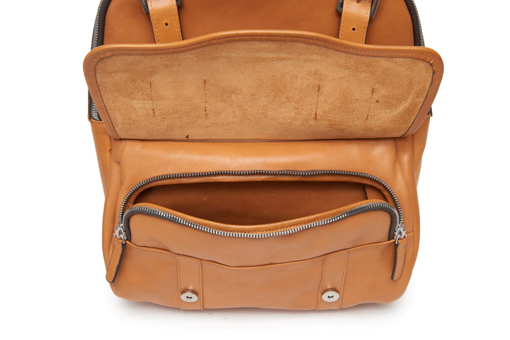 Tan Handcrafted with full grain American leather Padded backpack shoulder straps Roomy interior and front pocket Keychain attachment Interior organizer panel Fits up to a 15" laptop  Strap designed for easy carry on telescoping luggage handles Handcrafted with care in our own factory Natural leather lining Dimensions: 17" x 7" x 12" #color_tan