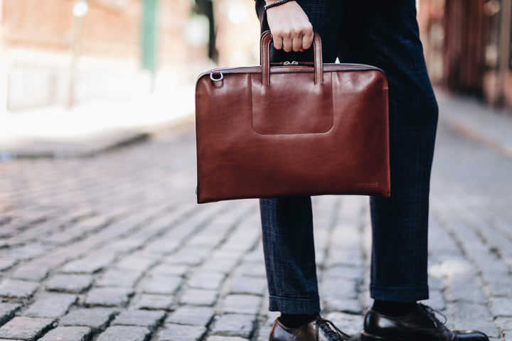 Solid Brass hardware in matte nickel finish Full length solid brass polished tooth zipper allowing lay flat use Adjustable, removable shoulder strap Handcrafted in our own factory Removable, padded computer sleeve designed for most 15" laptops Dimensions: 17" x 3" x 11.5" #color_brown